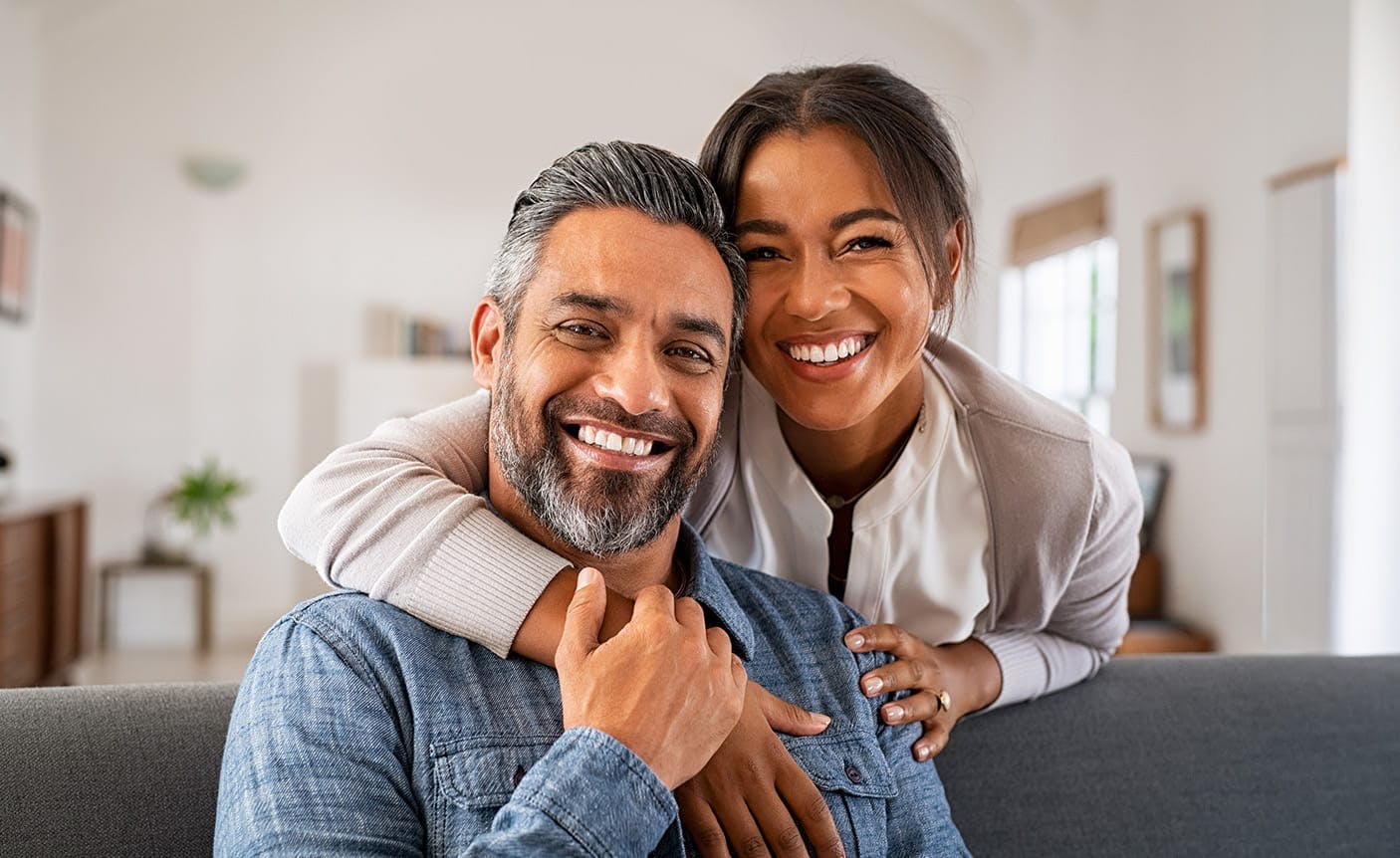 older woman leaning over an older man, smiling