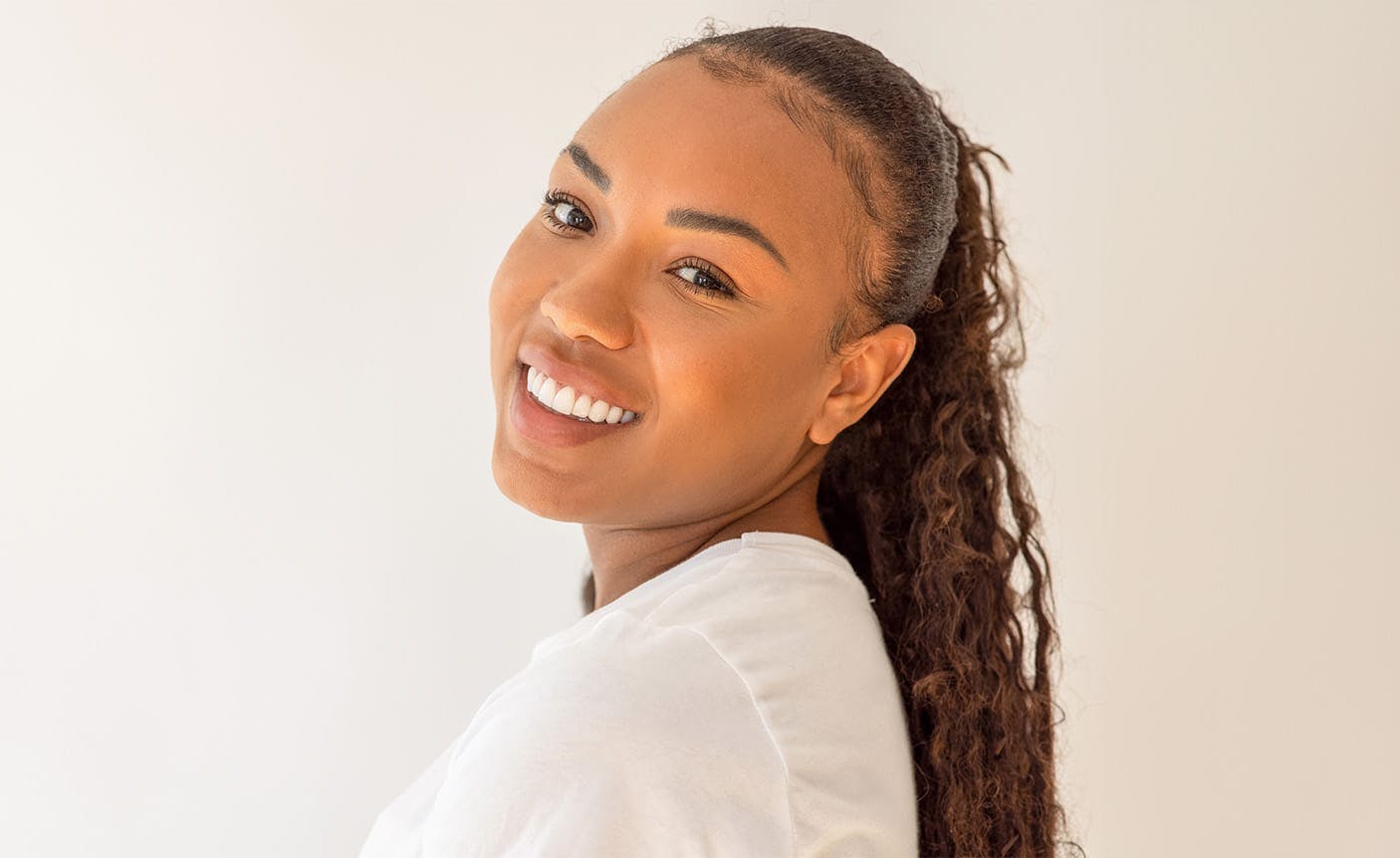 smiling woman looking over her shoulder
