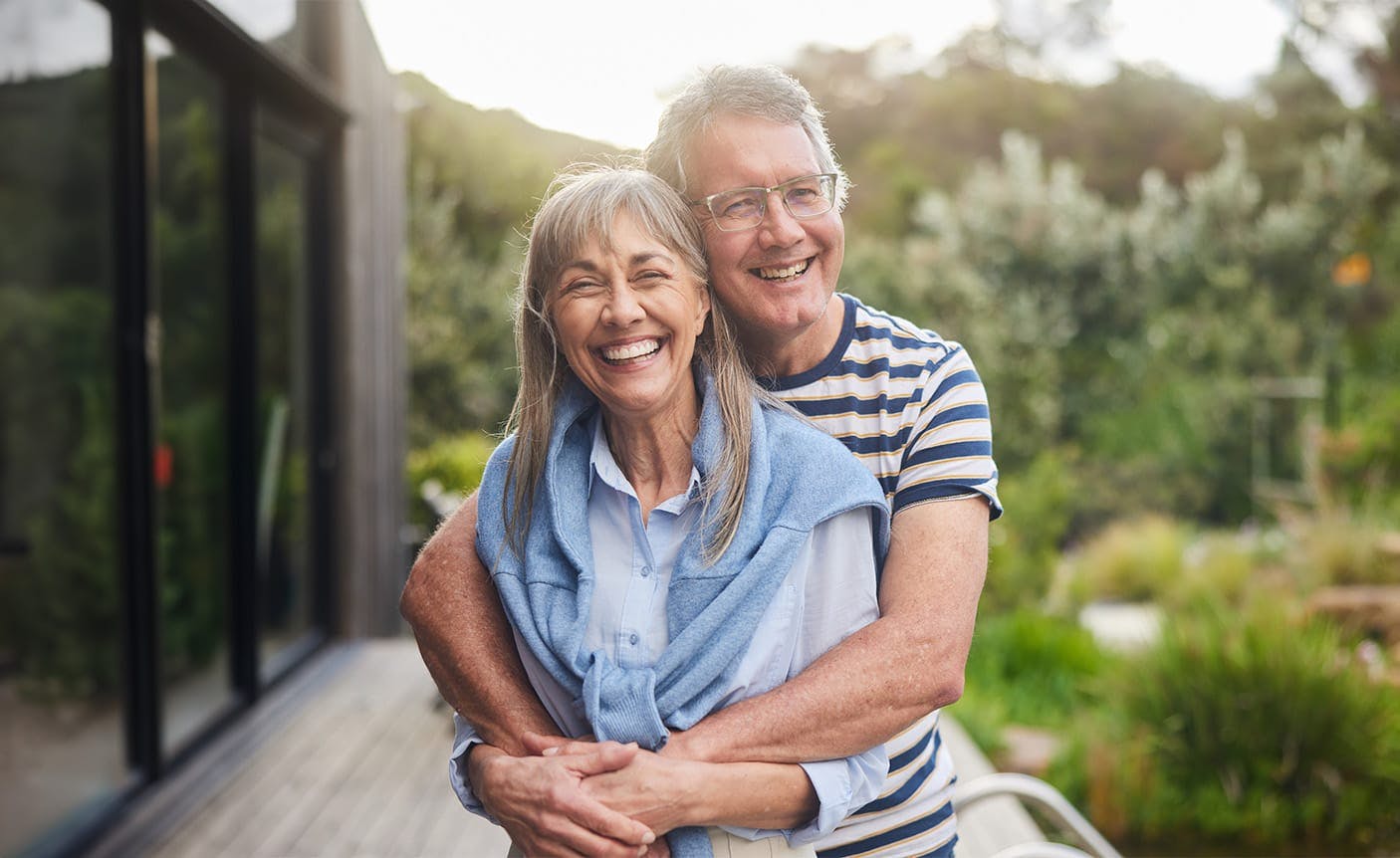 older man hugging an older woman from behind