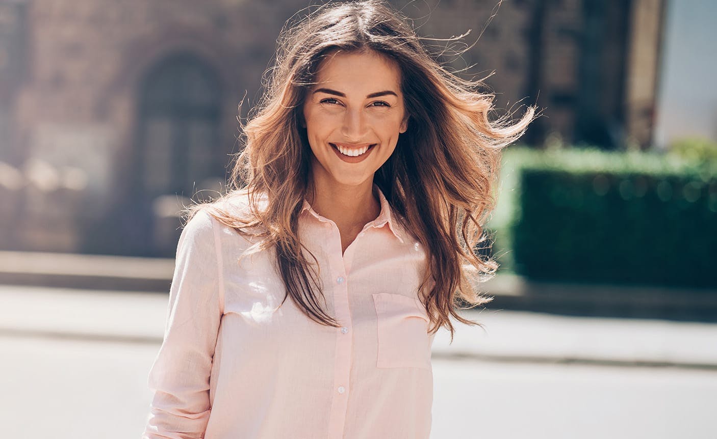 woman smiling with her hair blowing in the wind