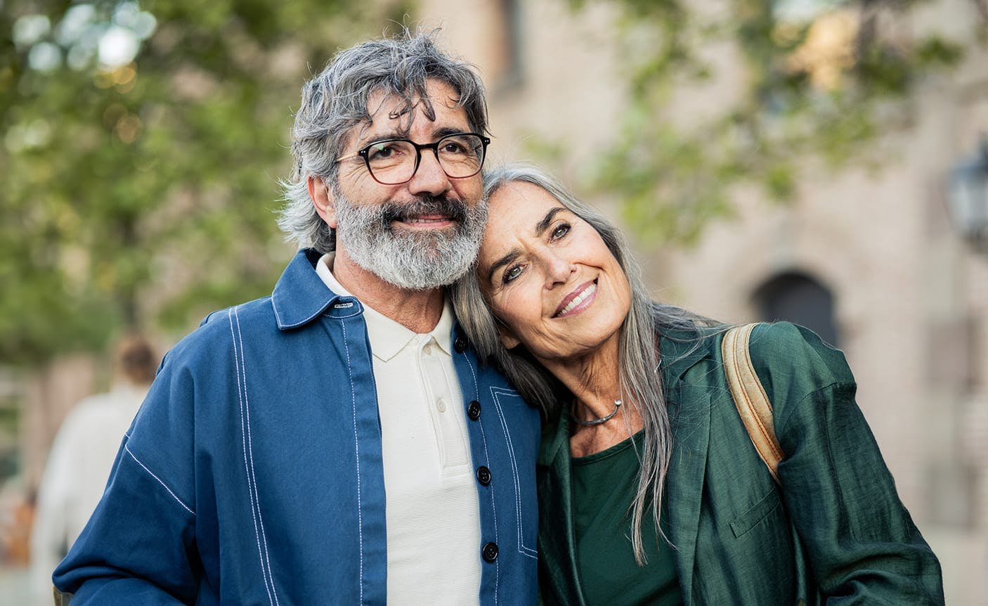 older woman leaning against an older man's shoulder