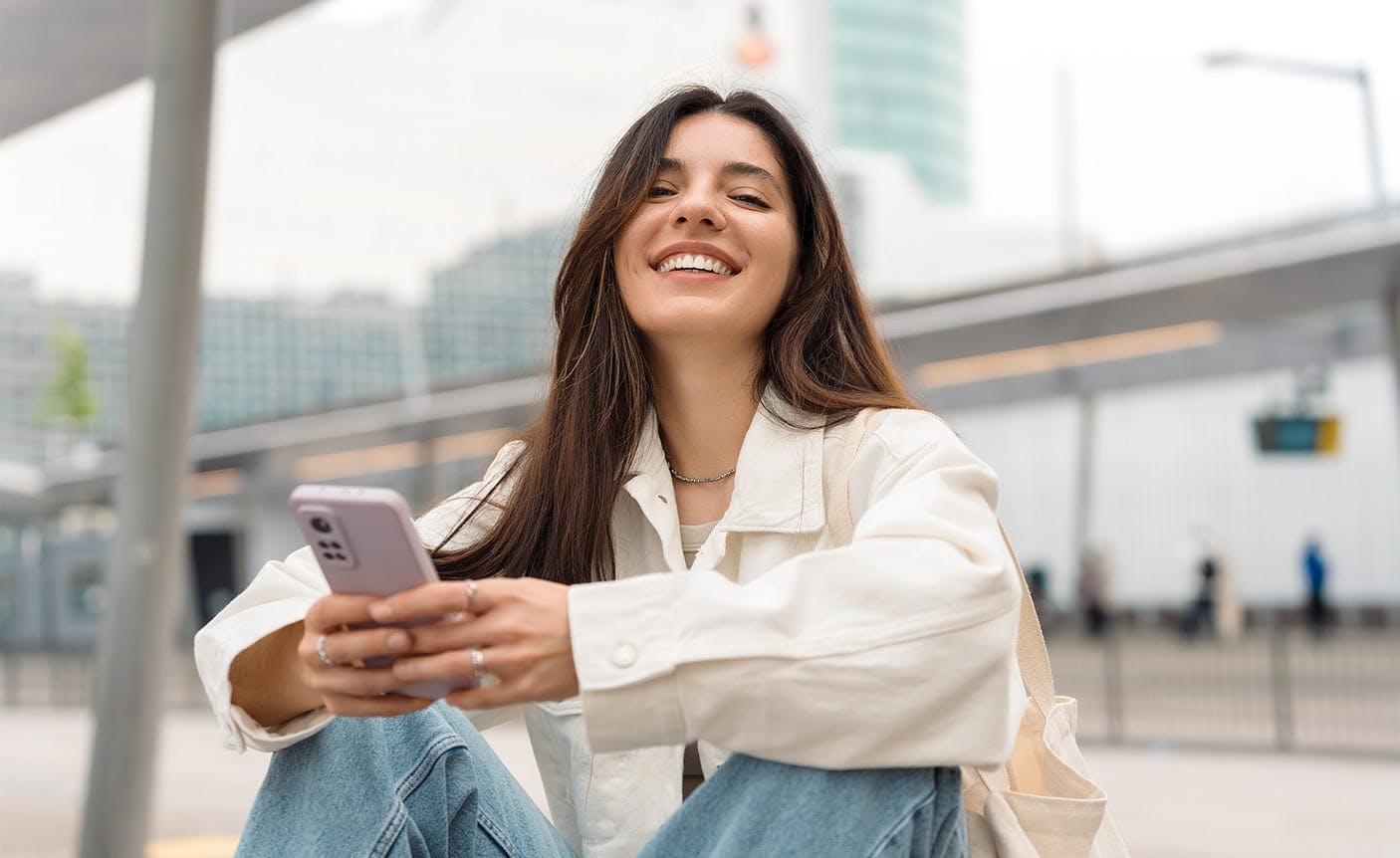 woman smiling, looking at her phone