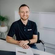 Carlo Capaul sitzt an seinem Arbeitsplatz und lächelt in die Kamera.