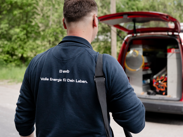 Elektroinstallateur läuft mit seiner Materialtasche zum Fahrzeug. Elektroinstallateur läuft mit seiner Materialtasche zum Fahrzeug.