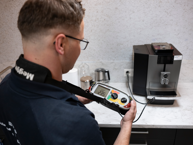Elektroinstallateur überprüft ein Gerät.