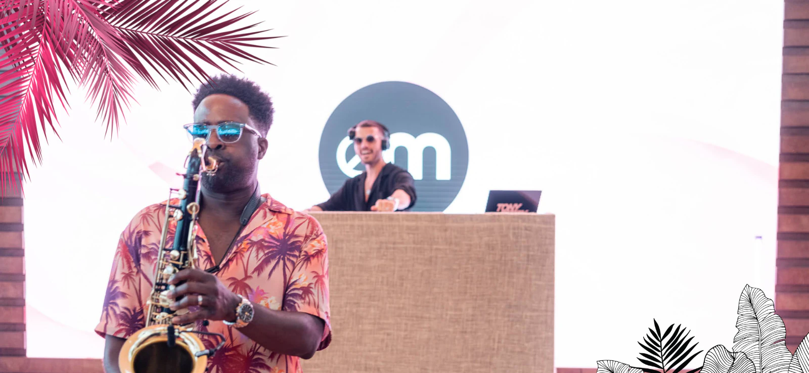 Person playing saxophone with a DJ in the background at an EssenceMediacom event in Cannes 2023