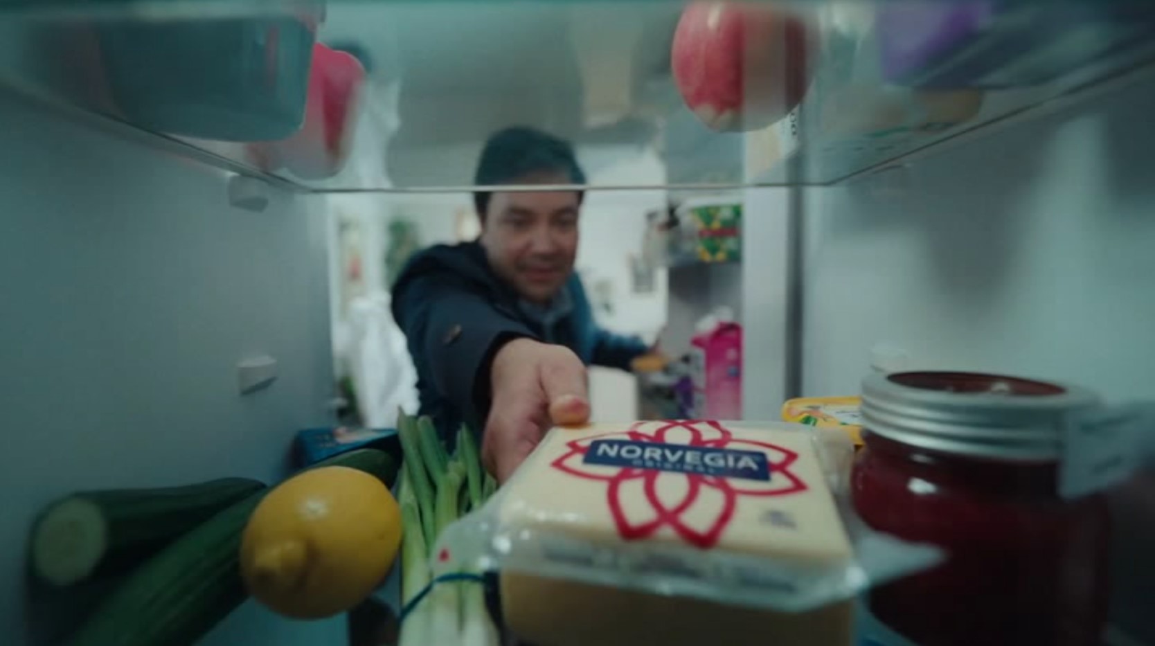 Man reaching into fridge to pick up cheese