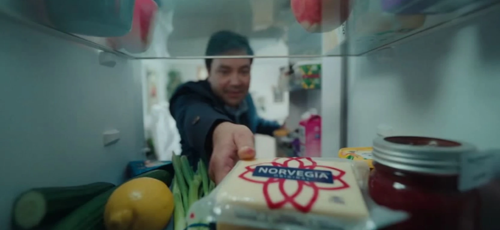 Man reaching into fridge to pick up cheese