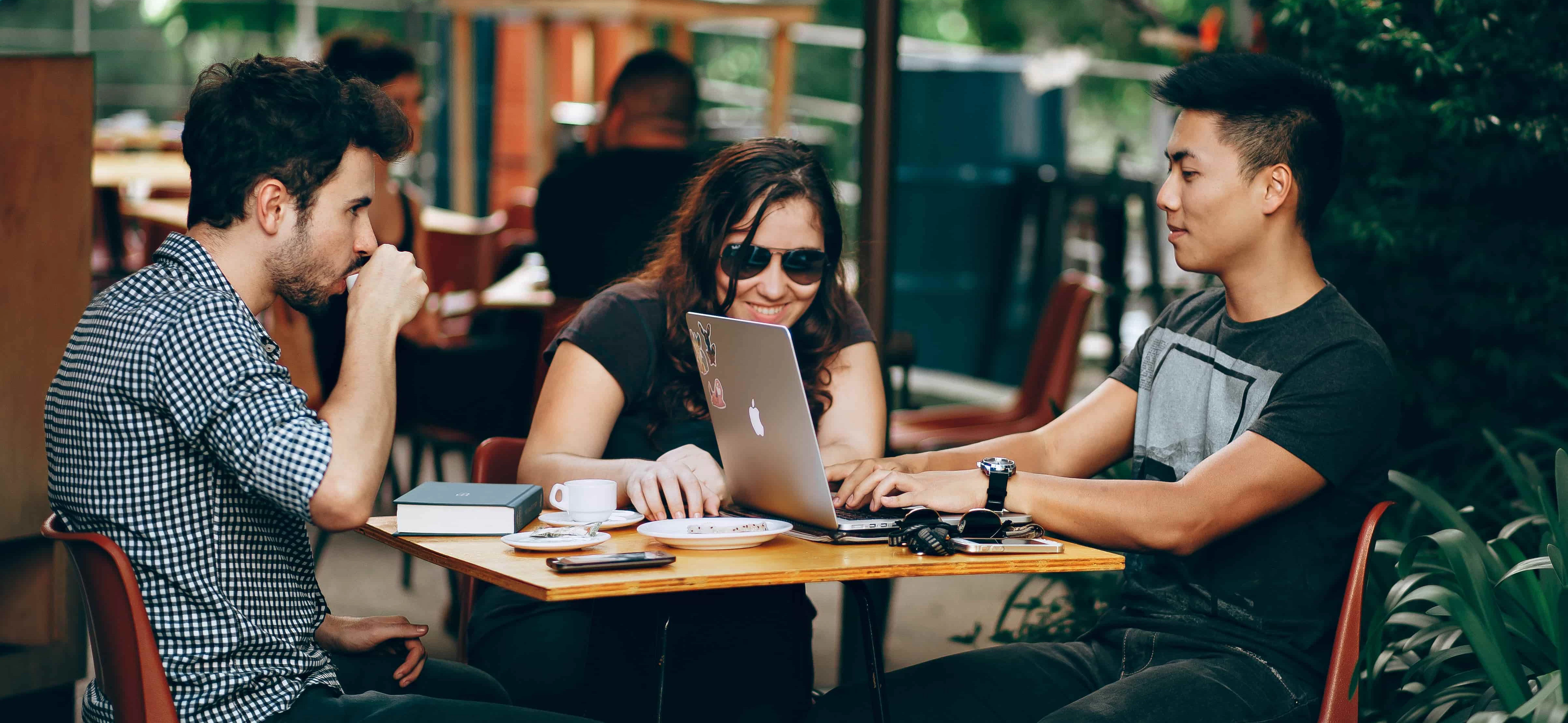 People drinking coffee and working at a table