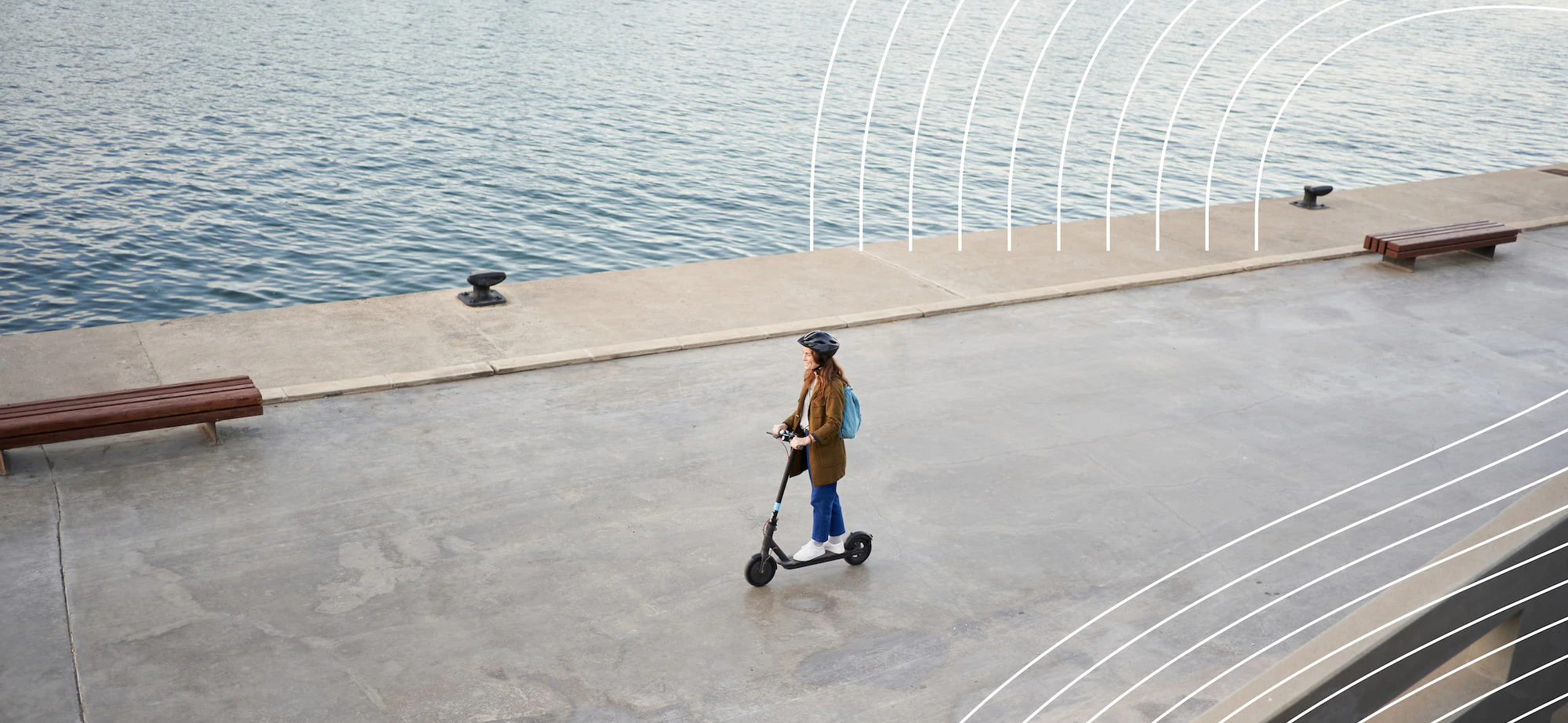 Image of a woman on a scooter next to a river