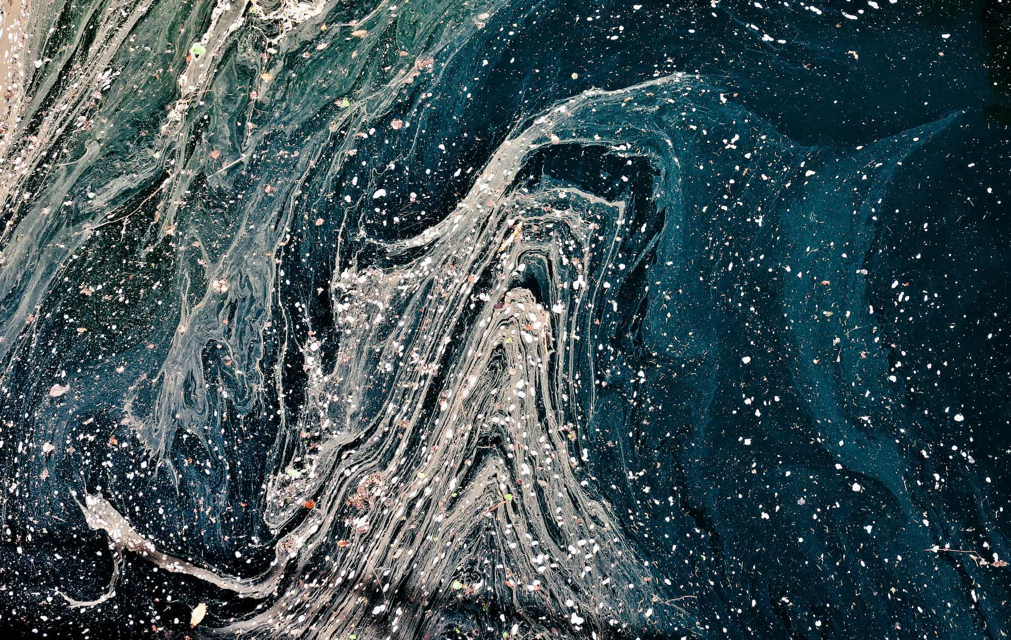 Aerial image of waves of waste and rubbish in the sea