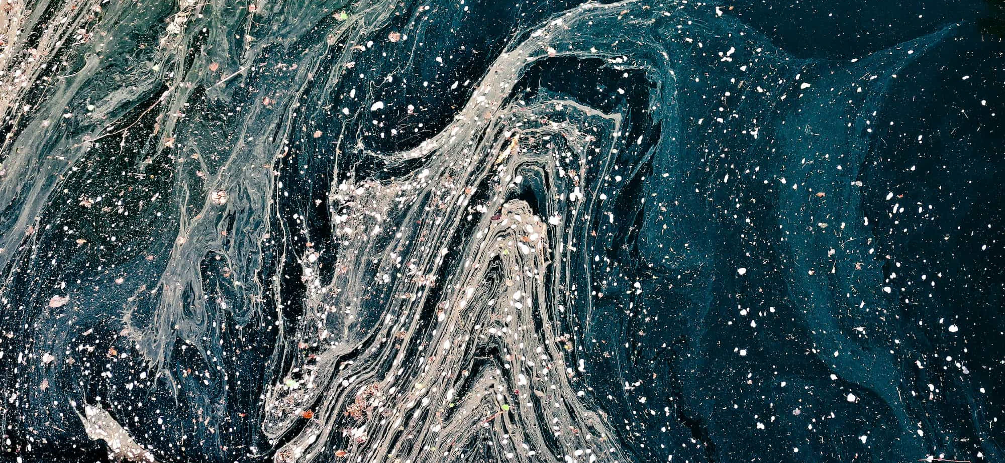 Aerial image of waves of waste and rubbish in the sea