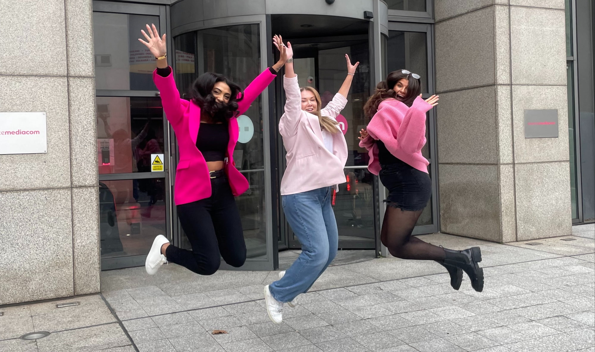 People jumping outside an office front door