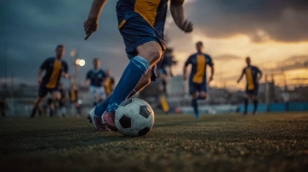 footballer kicking the ball across the field