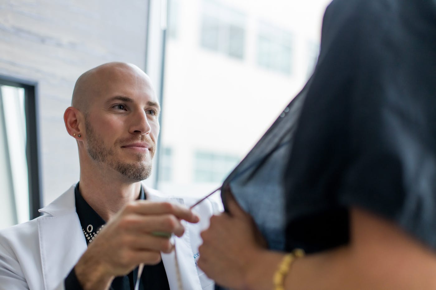 doctor looking at client's breasts