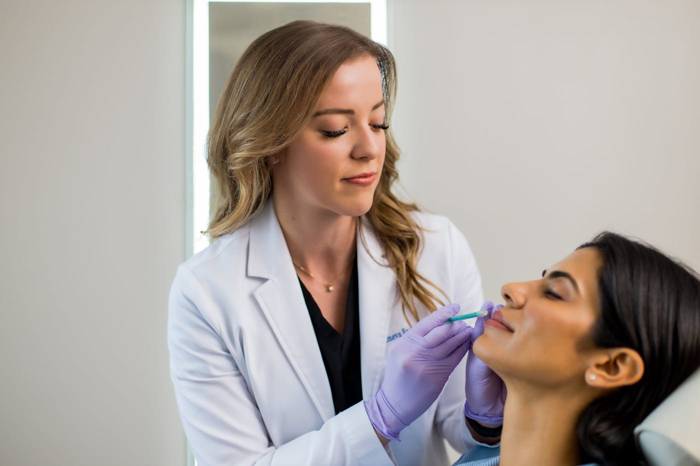client resting in chair with doctor inject into her face