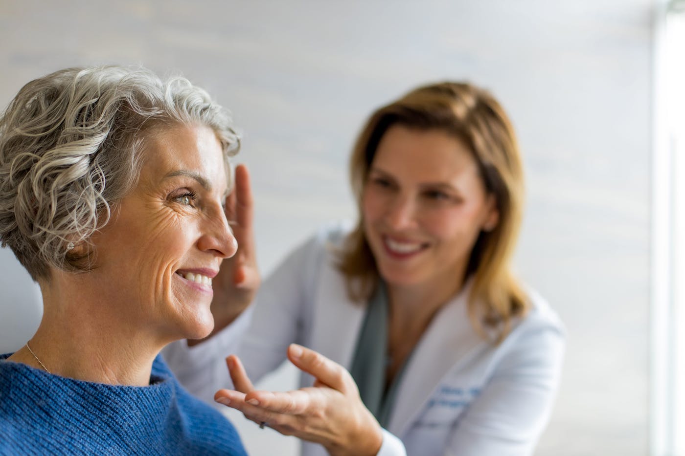 doctor smiling and examining client's face