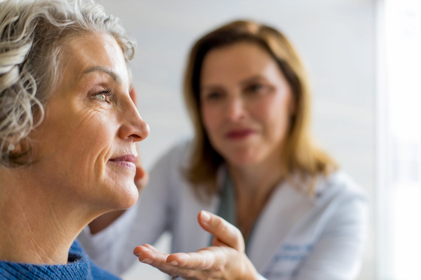 close up of client's face with doctor in background