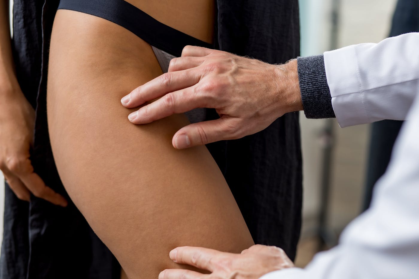 plastic surgeon touching woman's leg