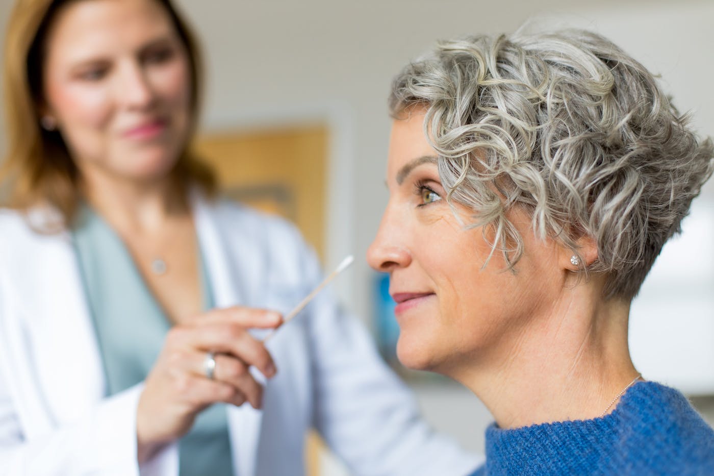 doctor holding q-tip to client's nose