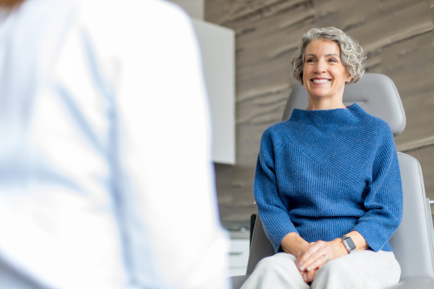 client sitting in chair smiling