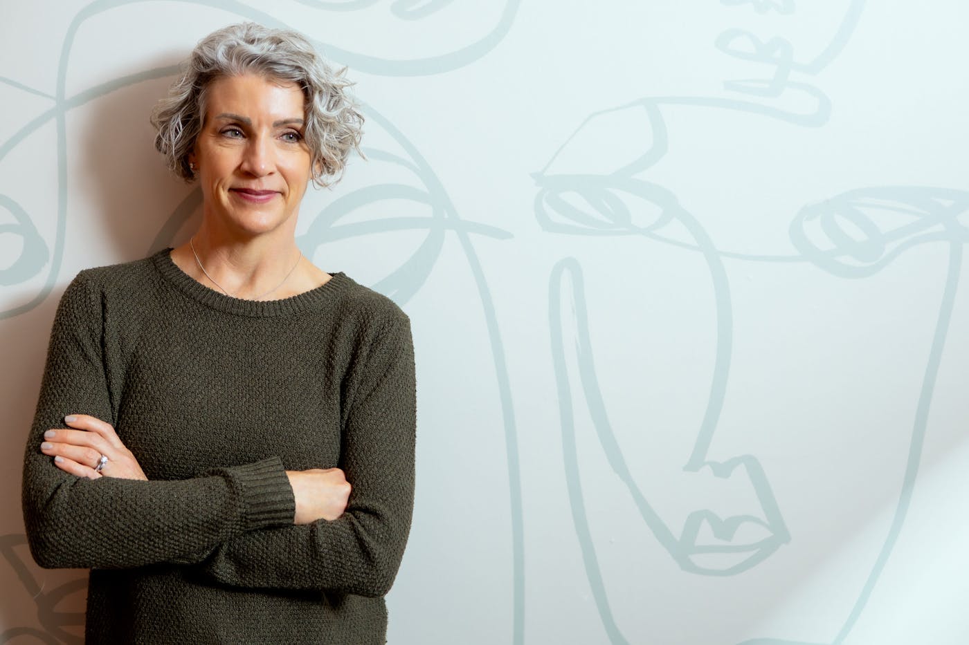 client standing against wall crossing her arms