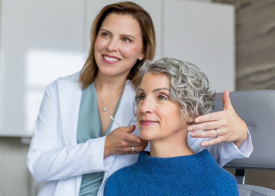 doctor and client looking into mirror for client's face