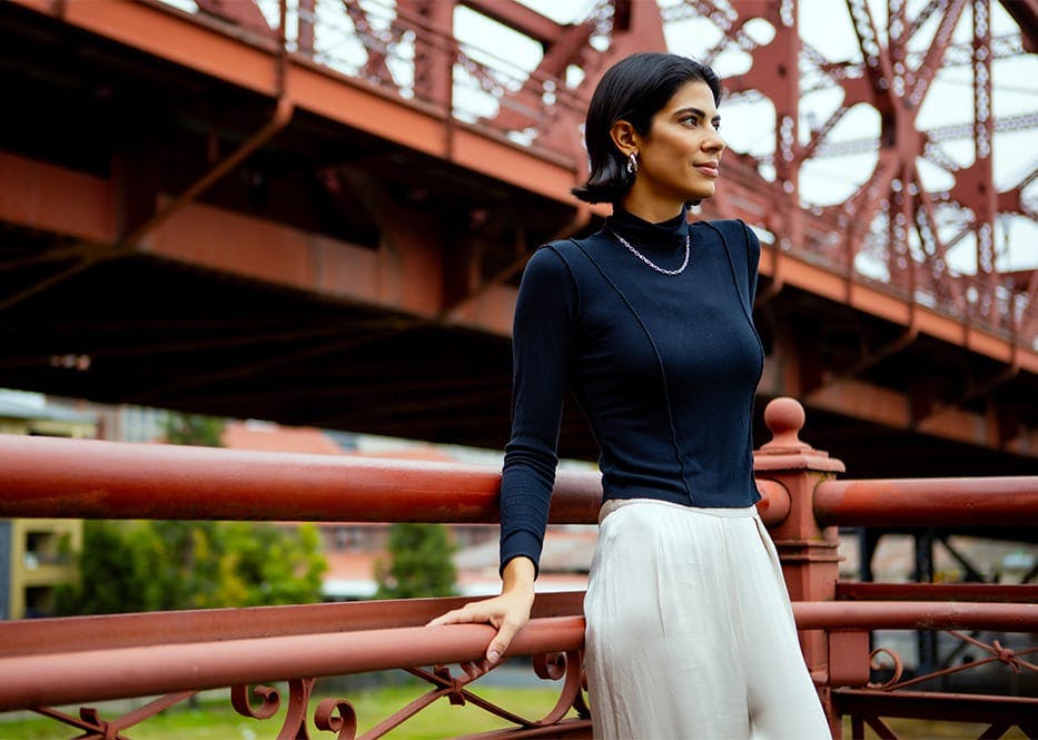 woman leaning against fencing for bridge