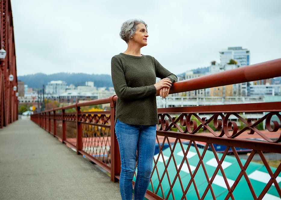 woman standing looking over to the view from the bridge