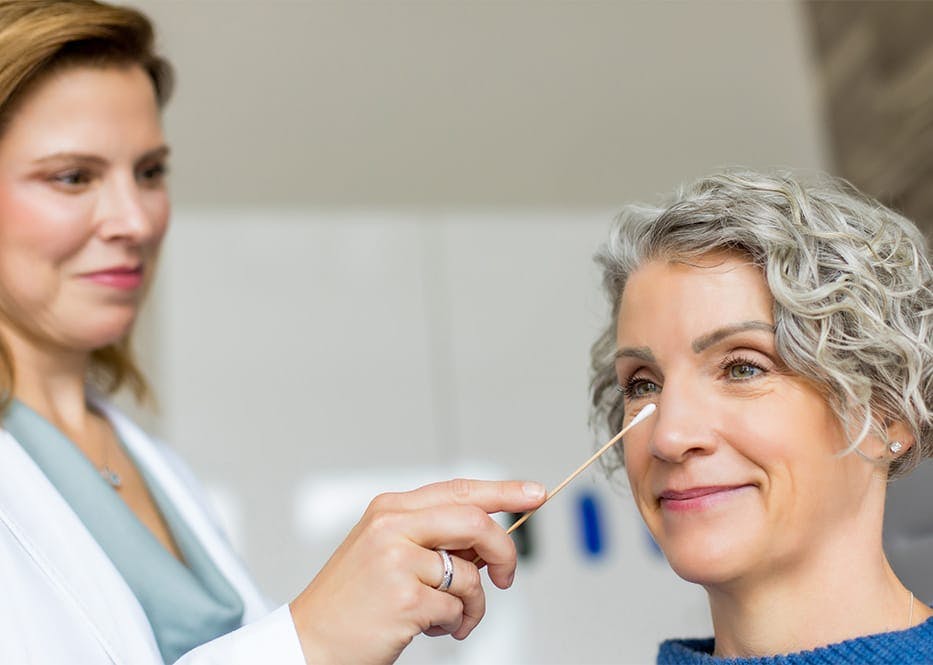 doctor holding q-tip close to client's nose