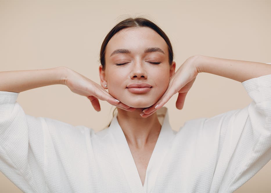 woman in robe with hands under her jaw