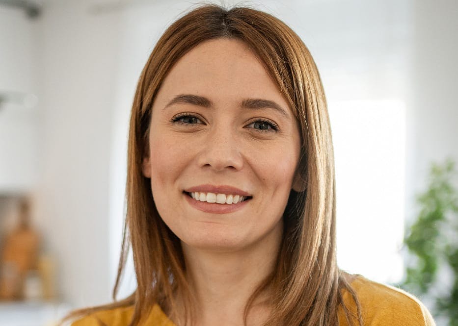 woman with light brown hair smiling forward