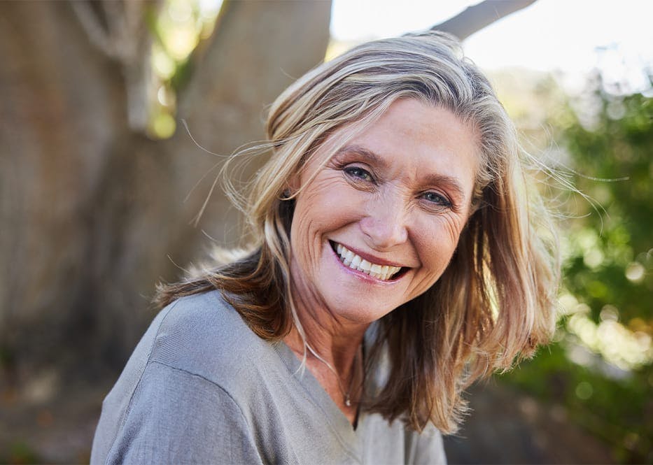 woman smiling with tree behind her