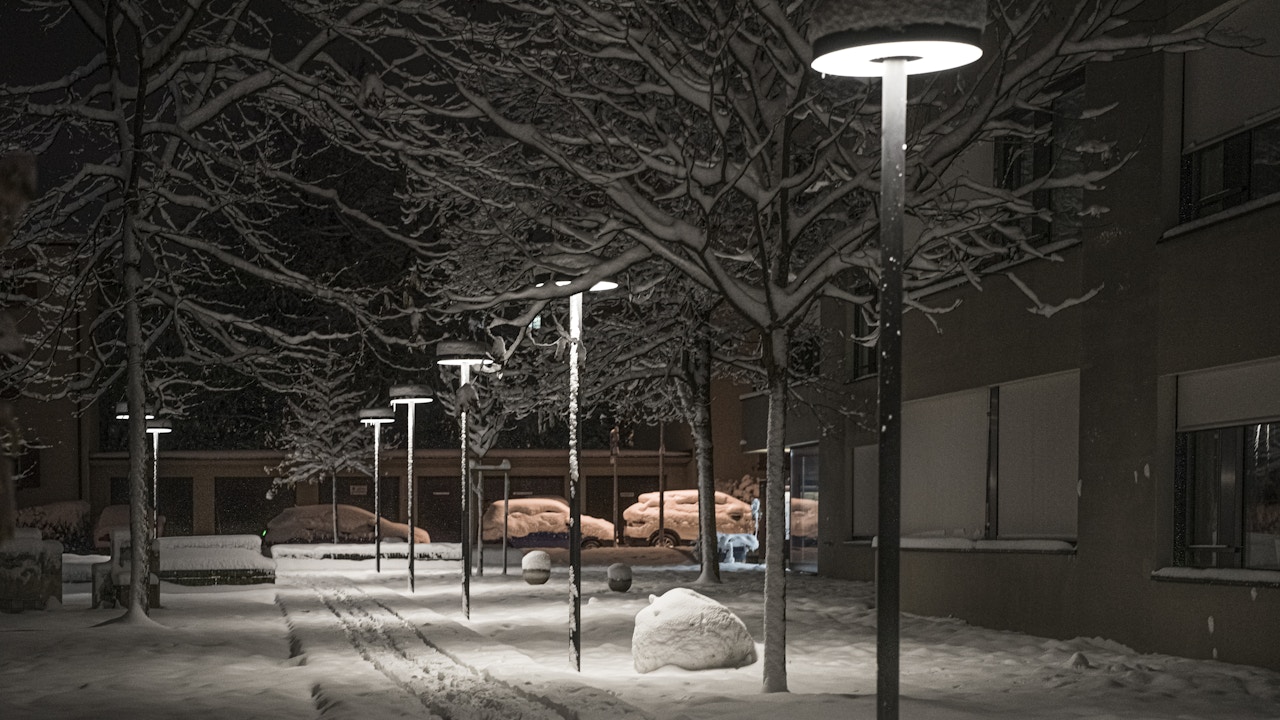 Die Lampen sind höher angebracht und beleuchten eine grössere Fläche, jedoch keine relevanten Elemente wie Baumkronen.
