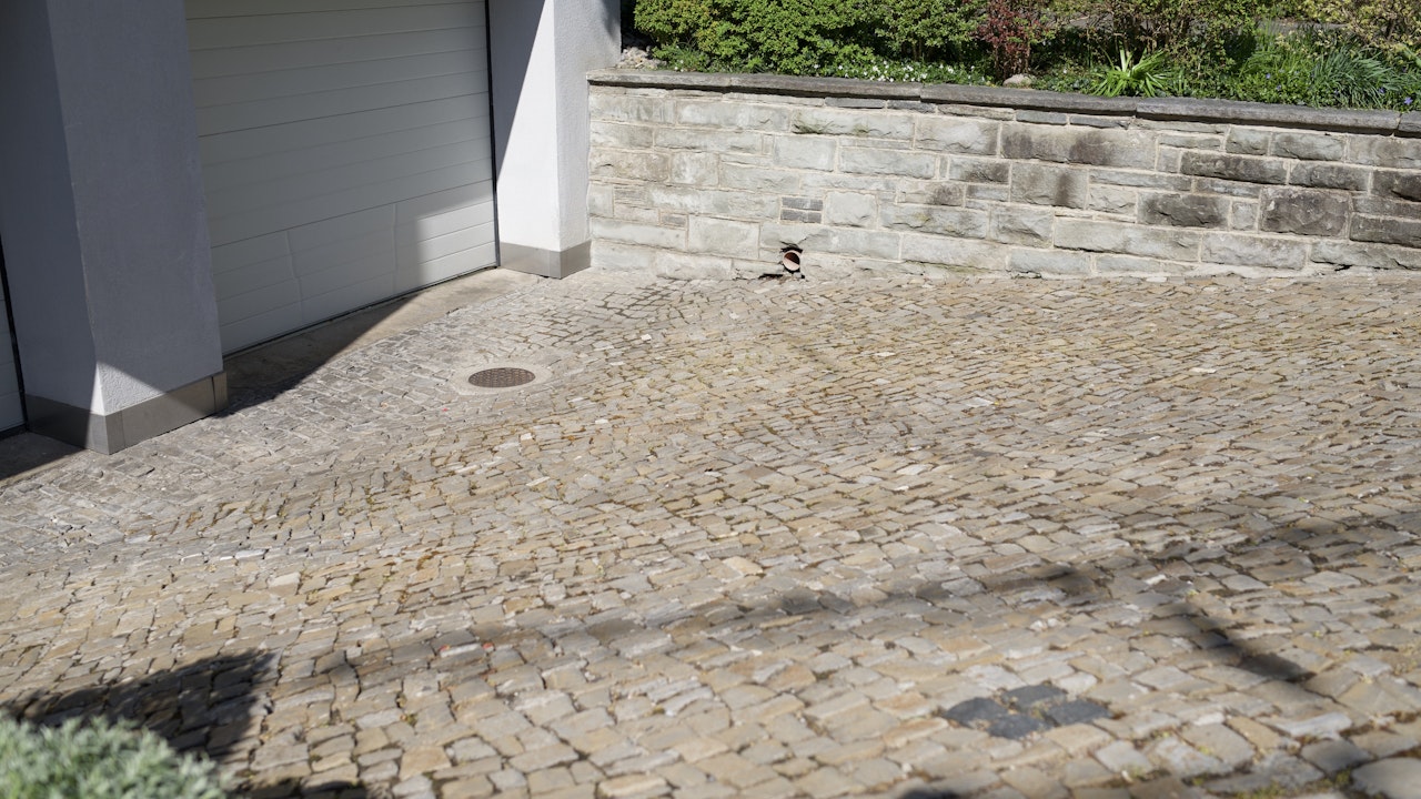 Die Pflasterung des Vorplatzes ermöglicht zusätzliche Regenwasserversickerung durch offene Fugen.