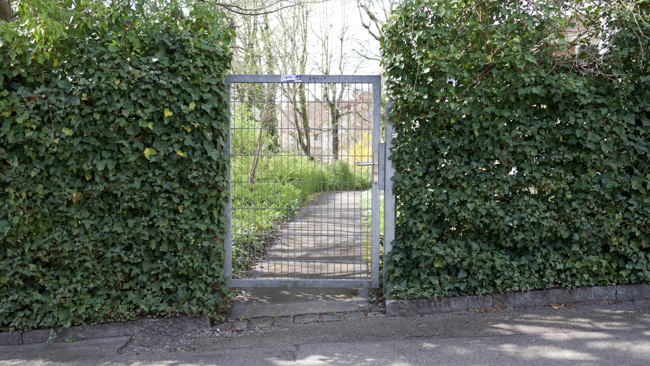 Durchlässige Stellen im Zauntor ermöglichen Igeln den Durchgang, während Efeu Schutz und Lebensraum bietet.