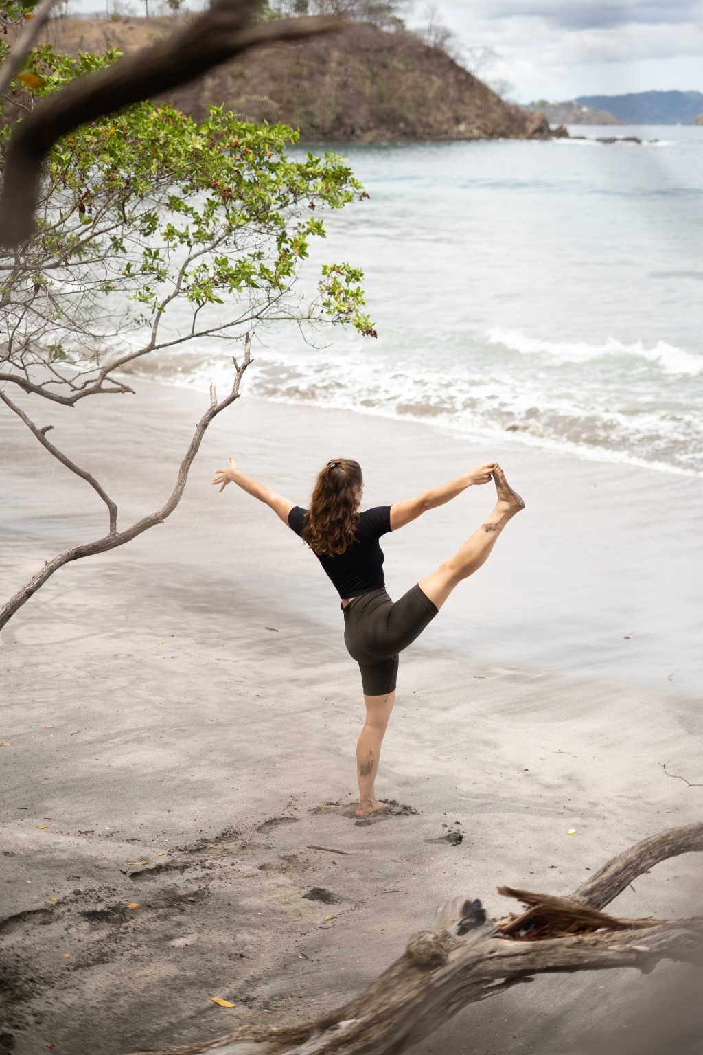 woman doing a yoga pose on the beach