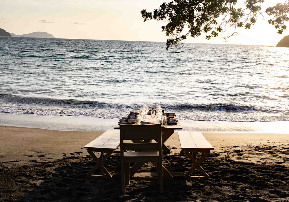 a picnic table on the ocean at dusk