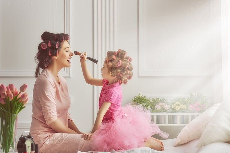 Child doing mother's makeup