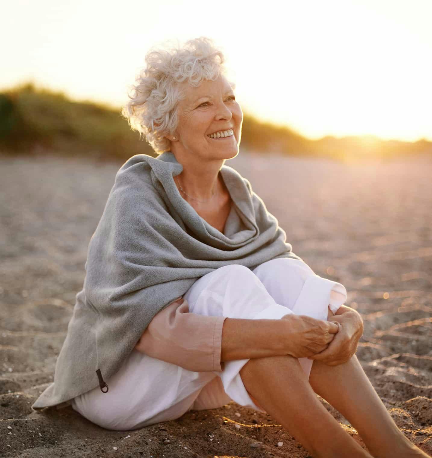 Older woman sitting on the beach