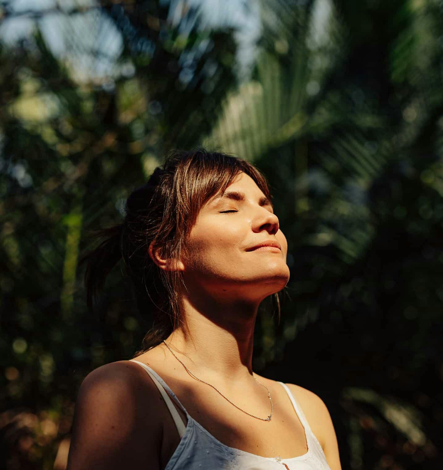 Woman outside with eyes closed