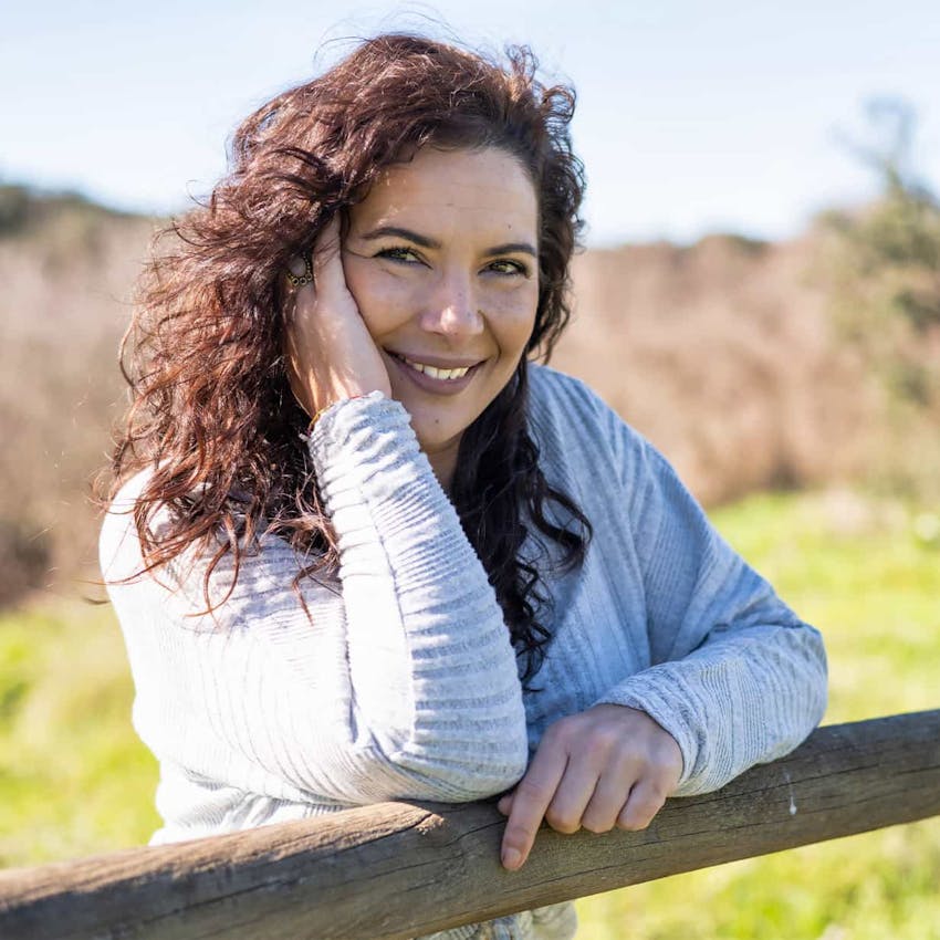 Woman smiling leaning on fence