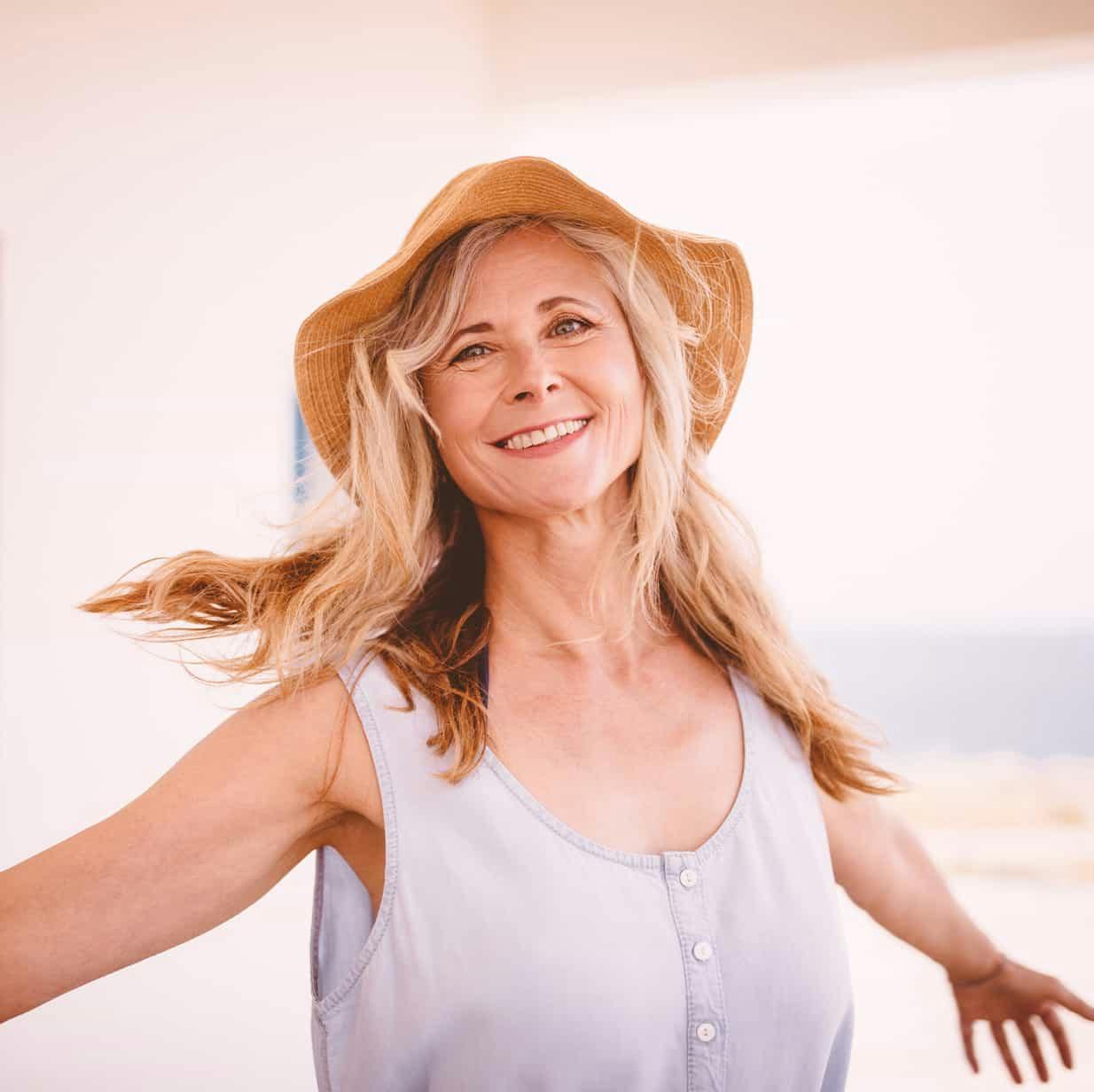 Woman outside smiling with hands out