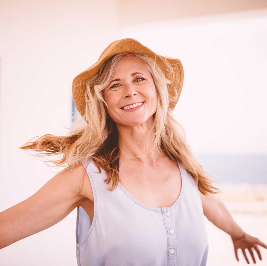 Woman outside smiling with hands out