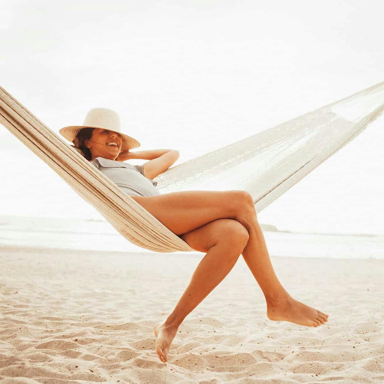 Woman sitting in a hammock outside