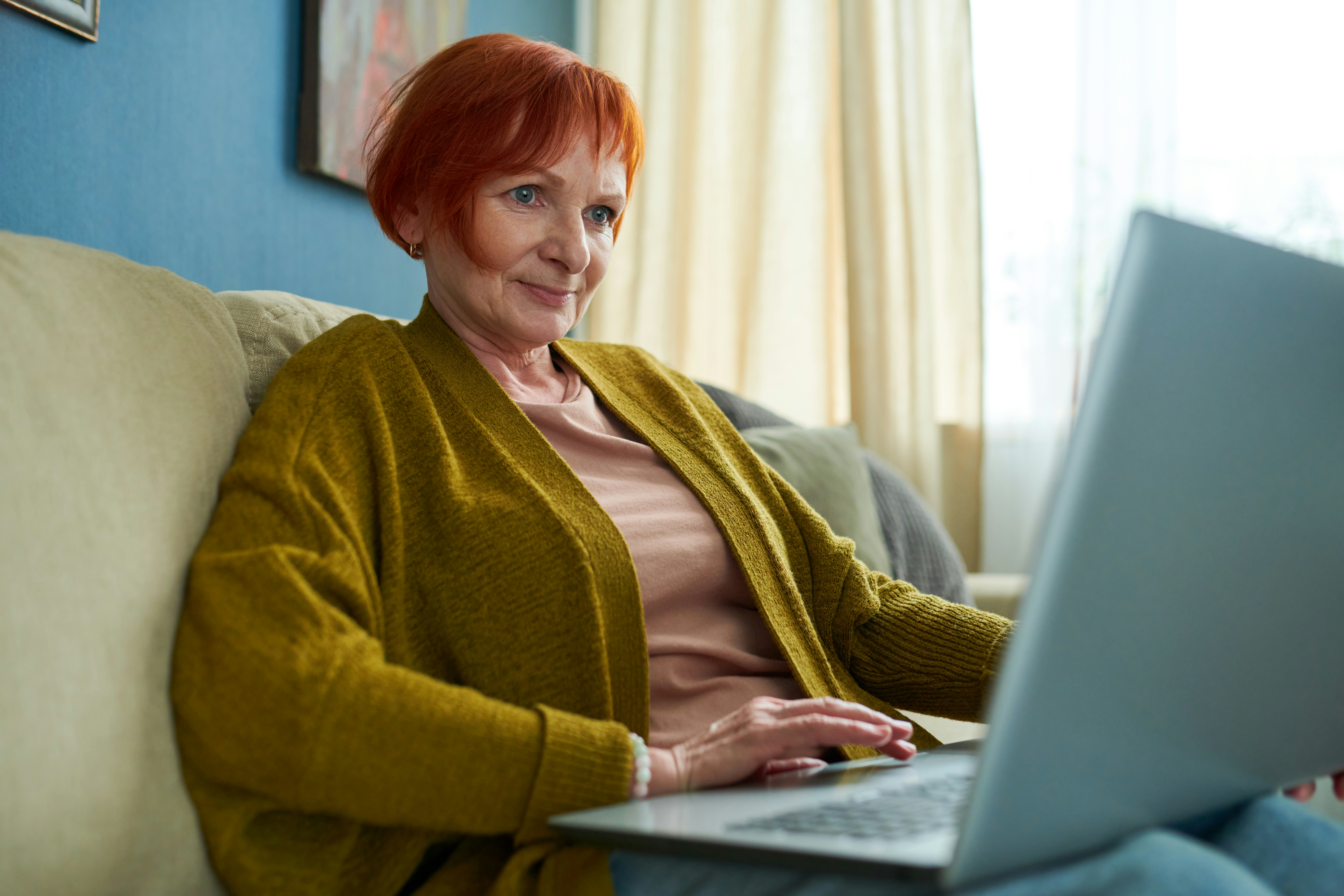 woman in green cardigan on laptop