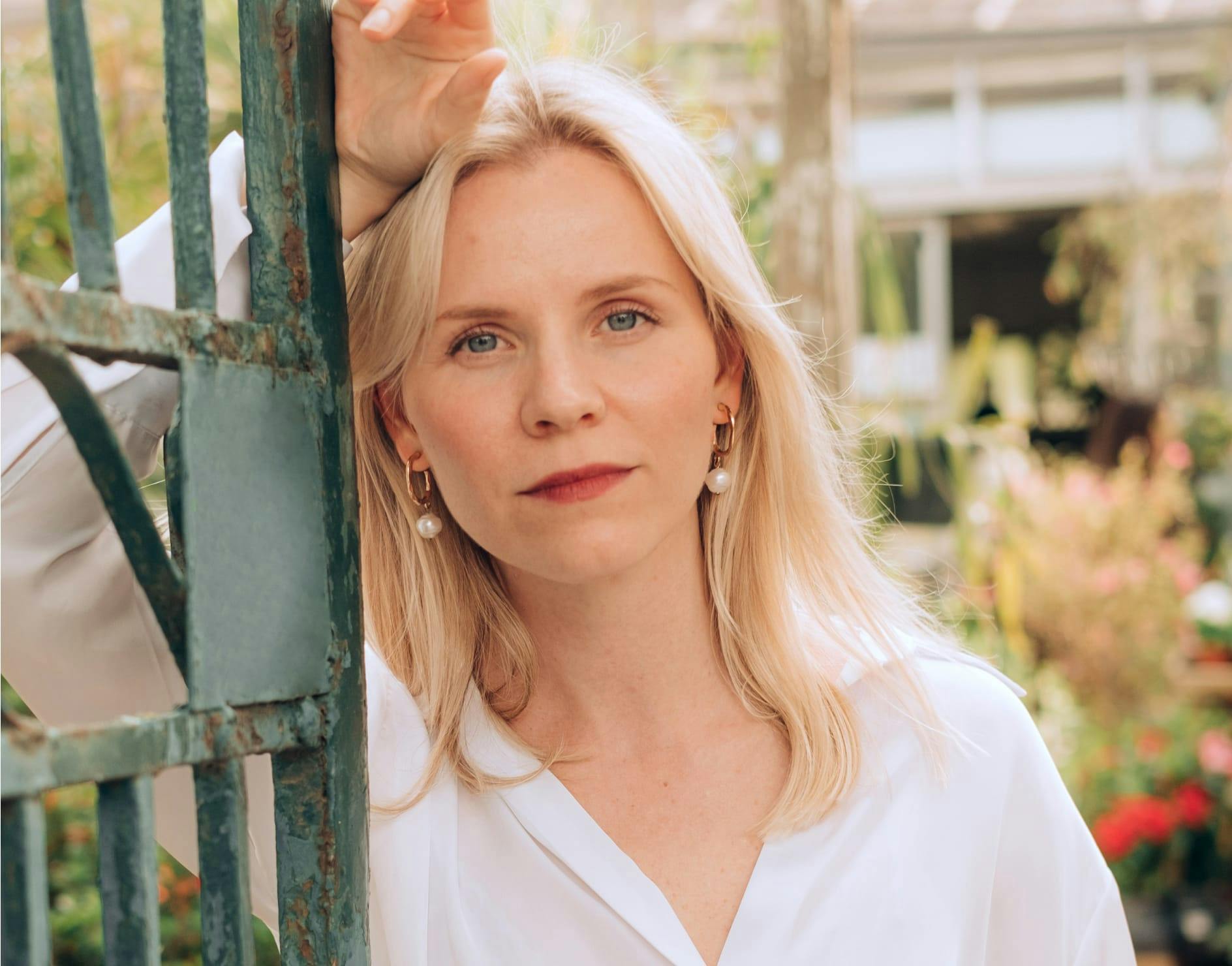 Woman leaning against a gate