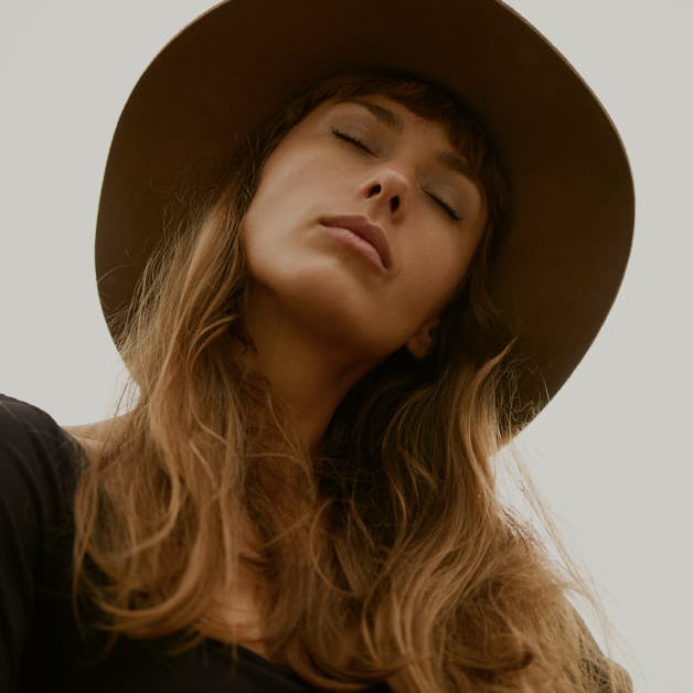 Woman with a hat on and her eyes closed