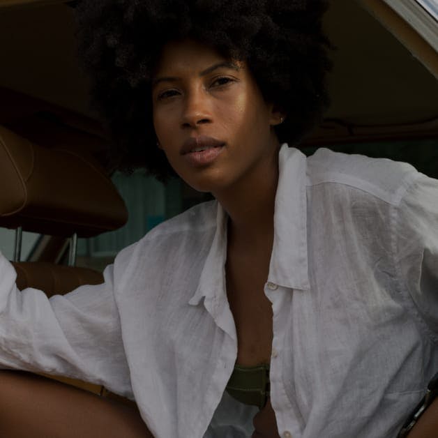 Woman with curly hair seated in a car