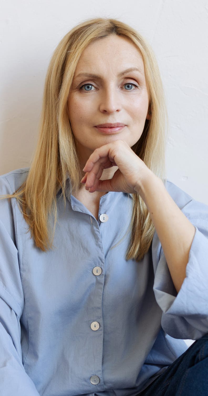 Woman with a blue top and a hand to her chin